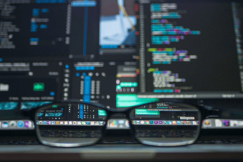 A pair of glasses sit in front of a computer screen featuring cybersecurity data