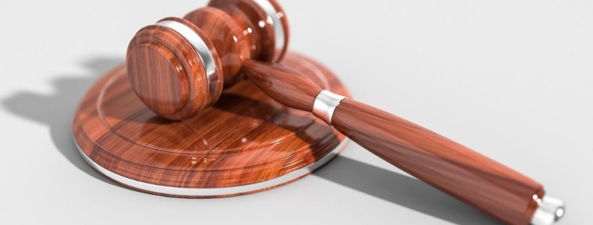 A polished gavel sits on a white table