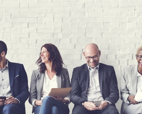 a group of professionals sitting next to each other with folders