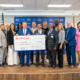 STU group holding ceremonial check from Santander US.