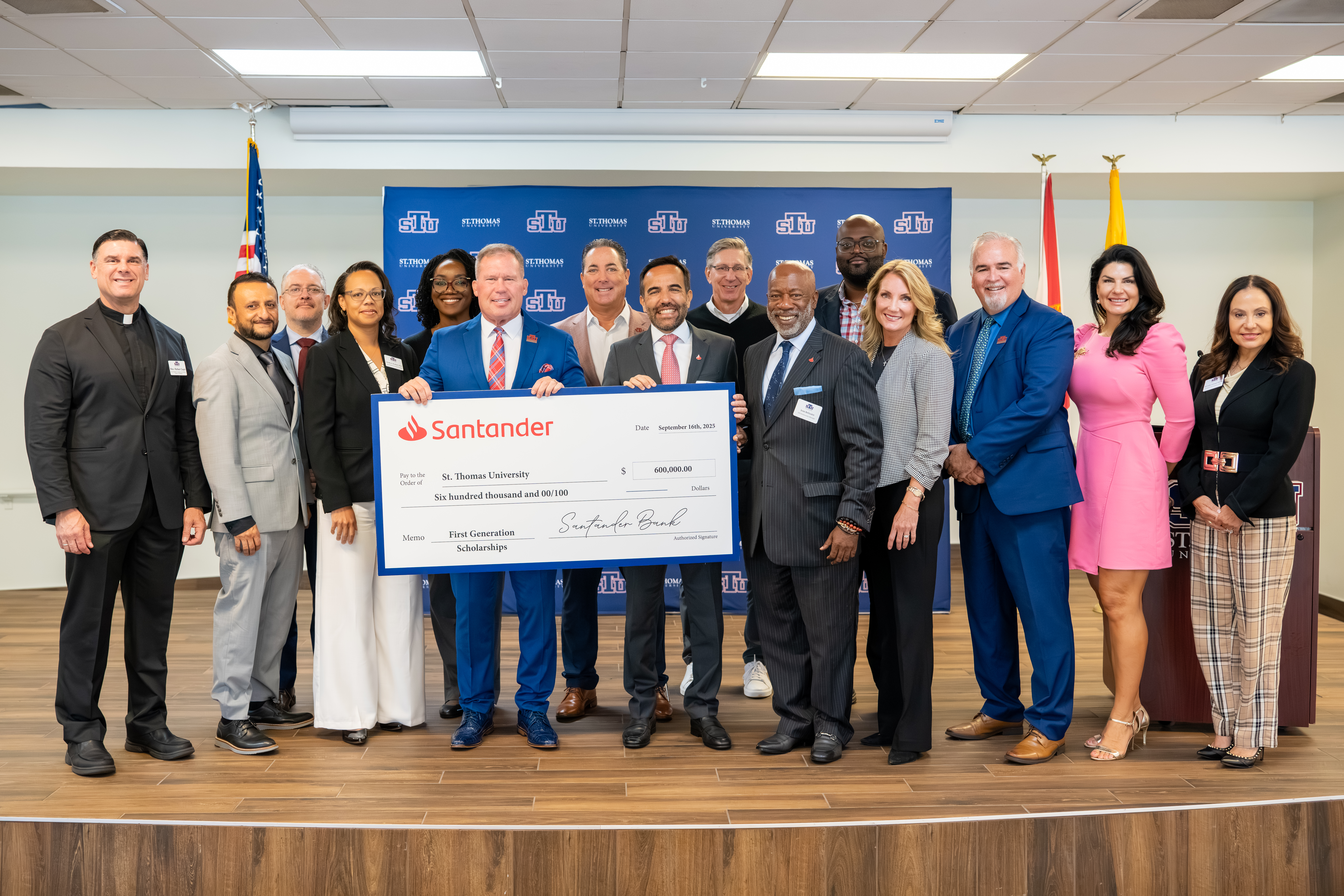 STU group holding ceremonial check from Santander US.