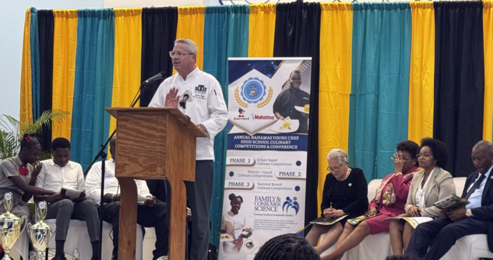 Bruce Ozga presenting on stage.